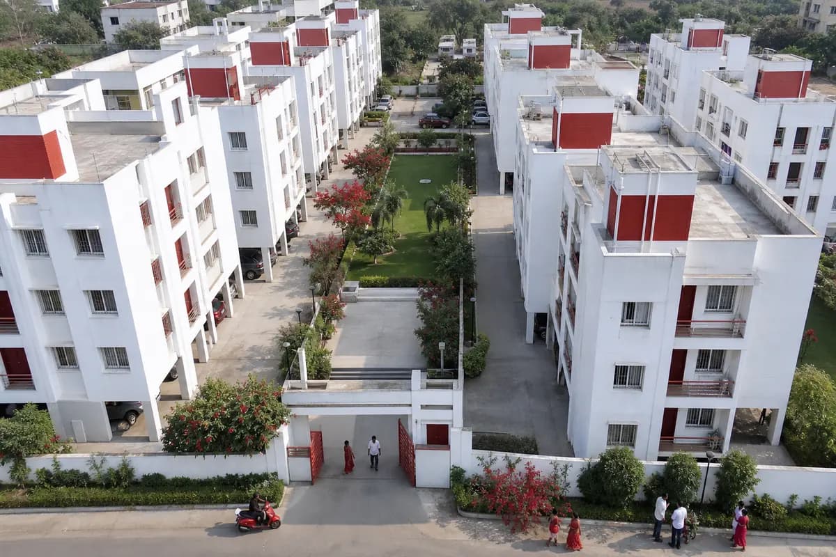 An aerial view of white residential towers around a central garden